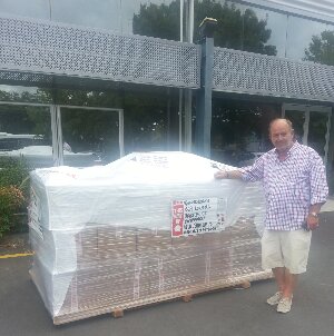 Graham Gibson standing beside pallet of crosses
